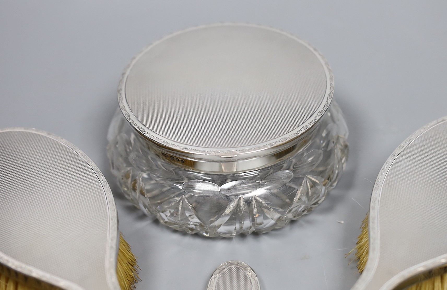 A 1960's seven piece engine turned silver backed brush, mirror and powder bowl set.